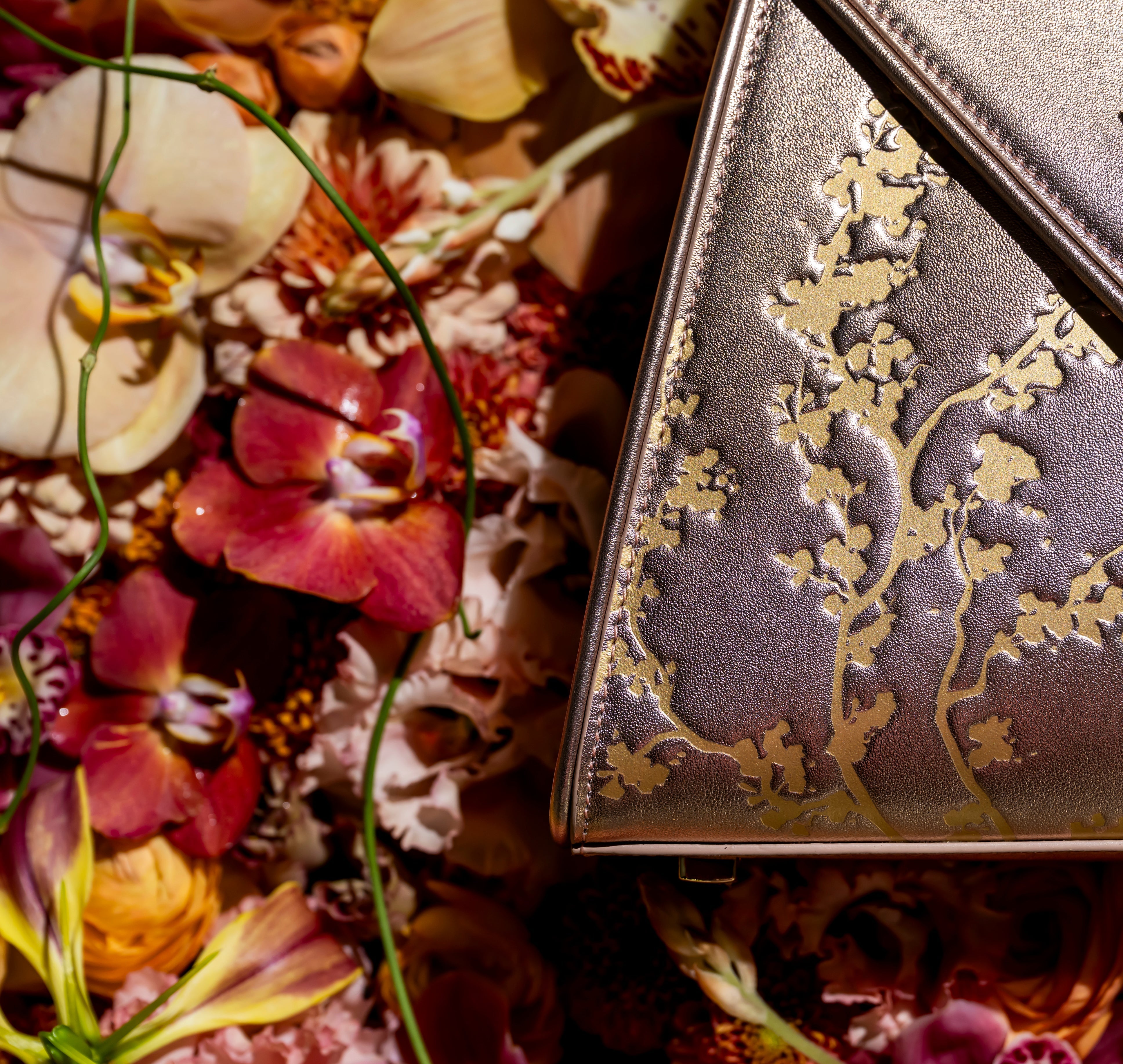 Silver clutch with floral design on a bed of flowers