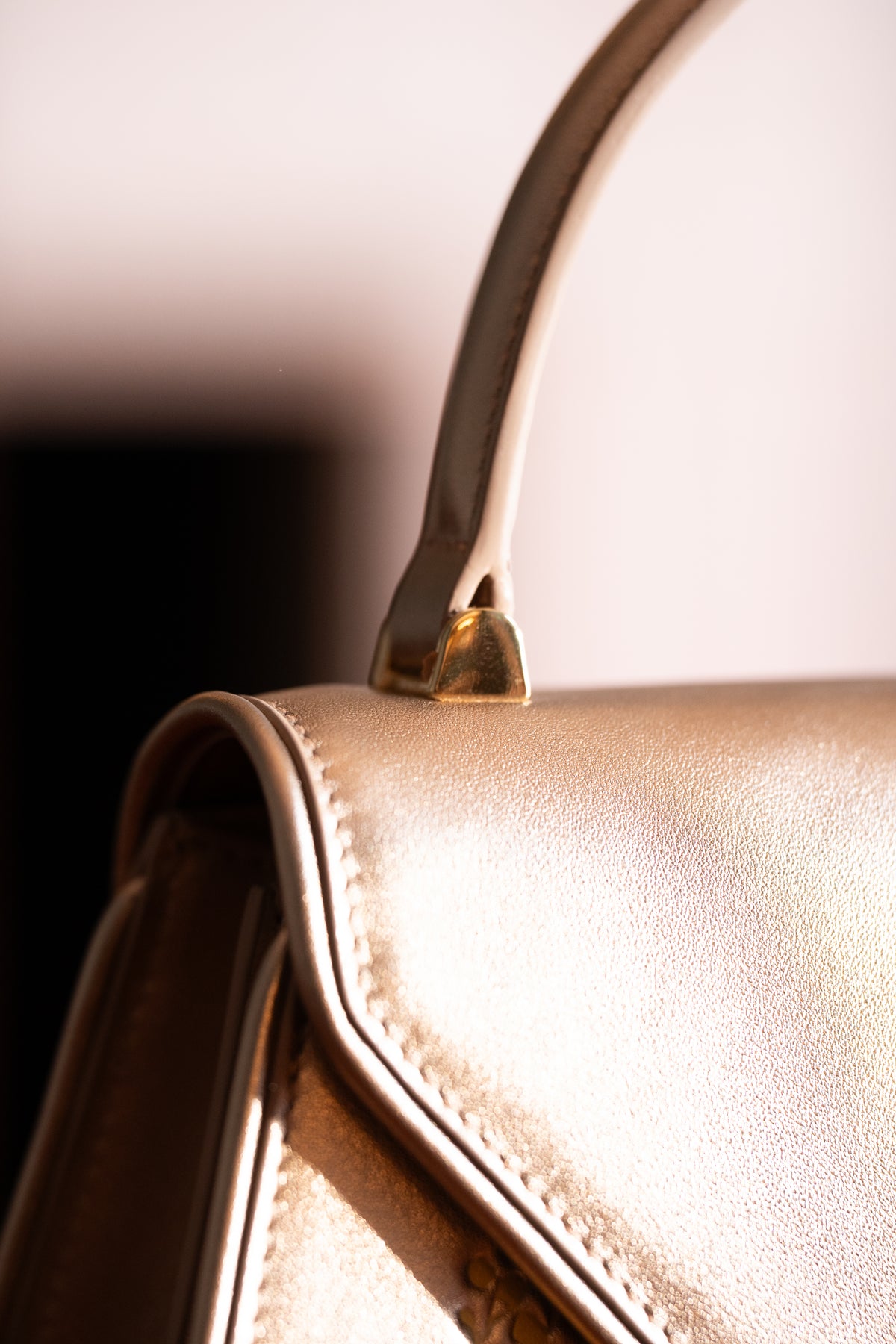Close-up of a gold handbag with a blurred background